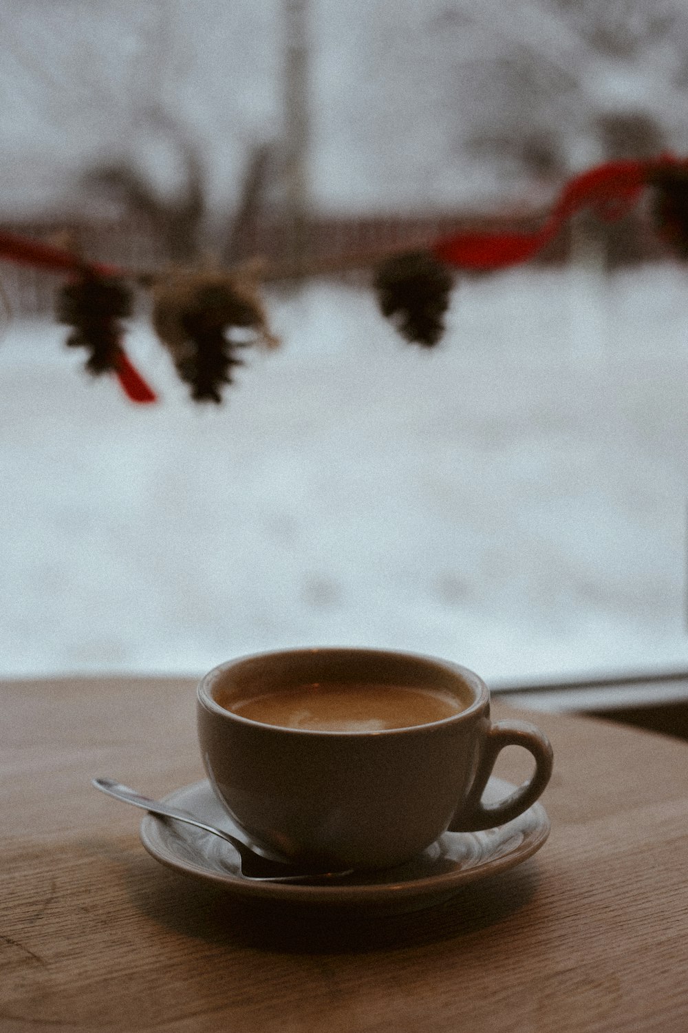 a cup of coffee sitting on top of a wooden table