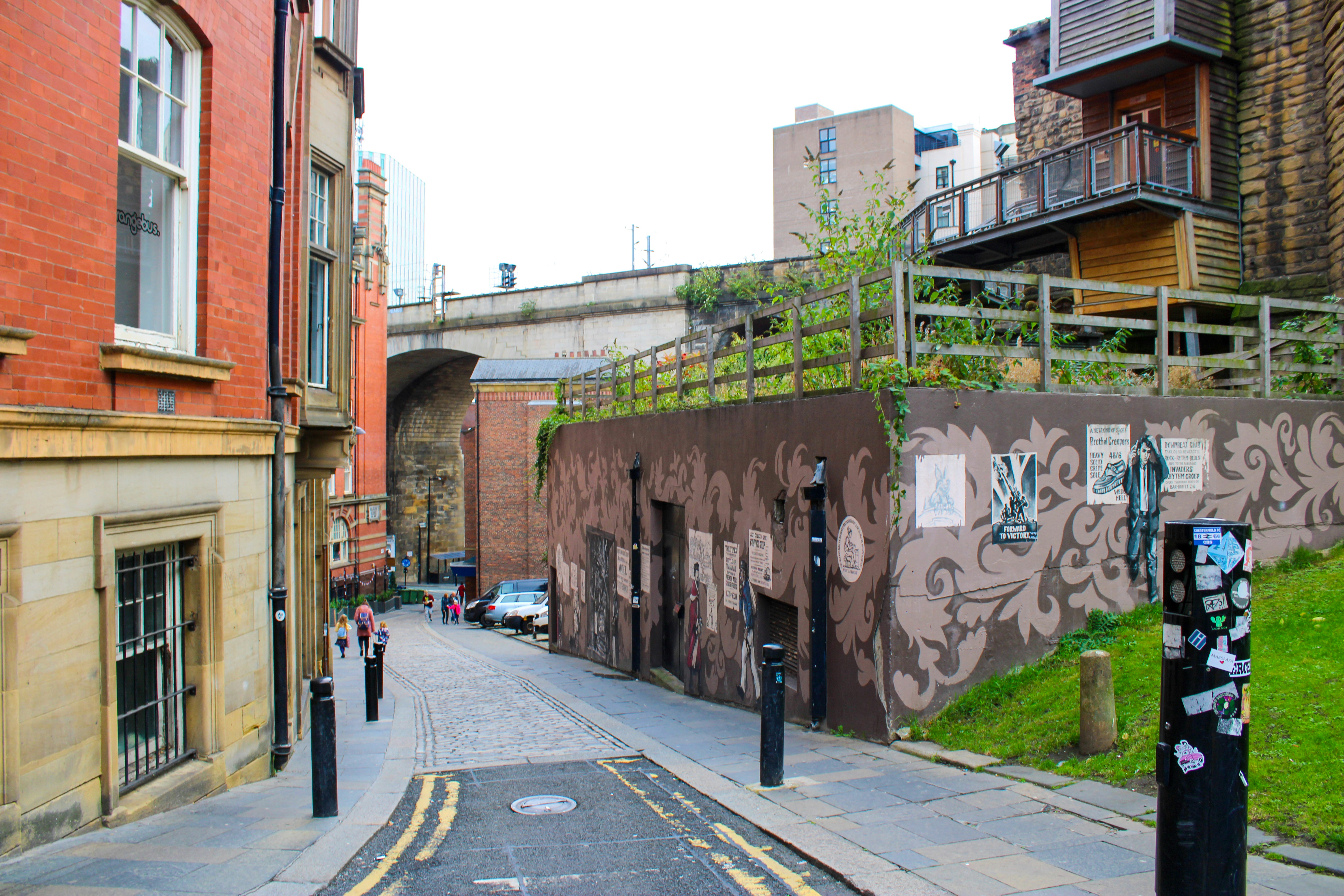 a narrow city street with a green roof