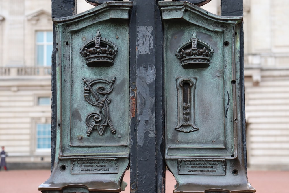 a close up of two metal doors with a building in the background
