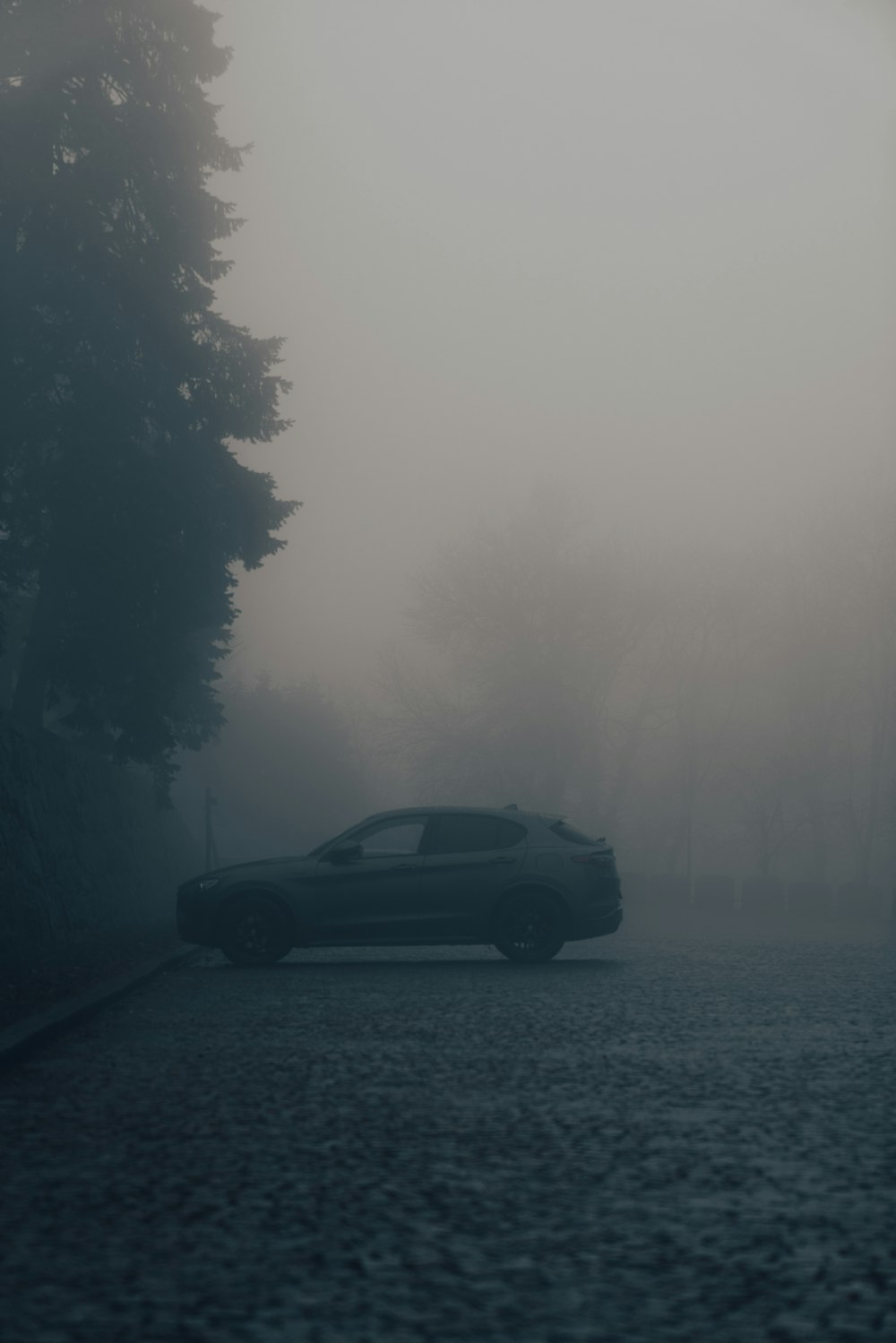 a car driving down a road in the fog