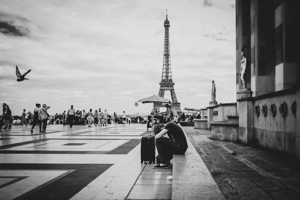 a man sitting on the ground next to a suitcase