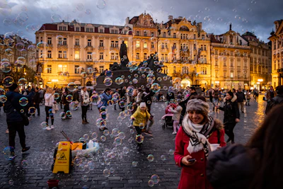 a group of people standing on a street next to a fountain