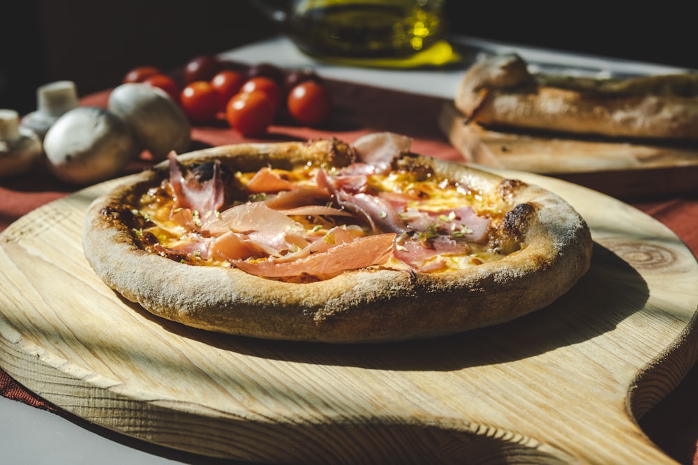 a pizza sitting on top of a wooden cutting board