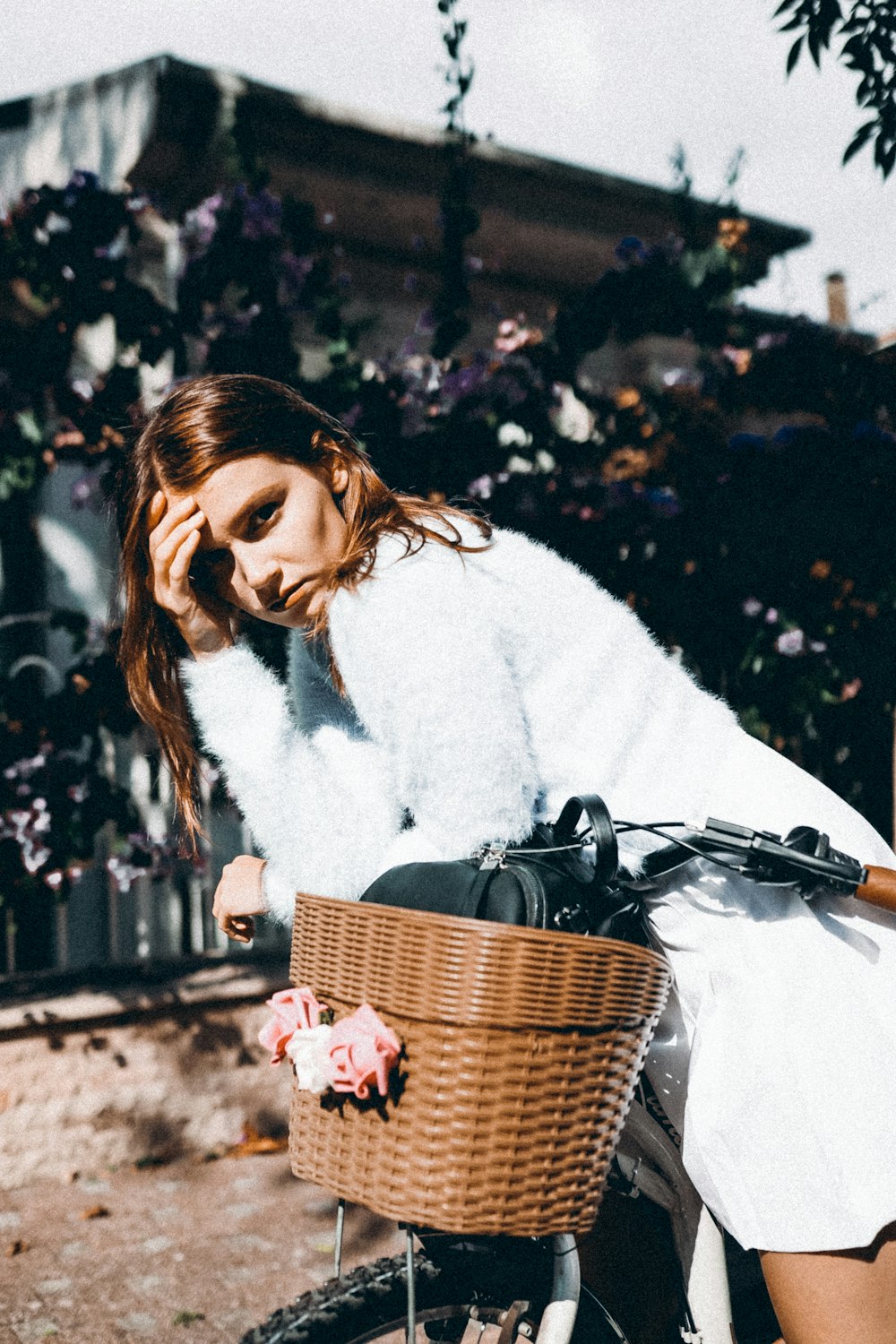 a woman sitting on a bike talking on a cell phone