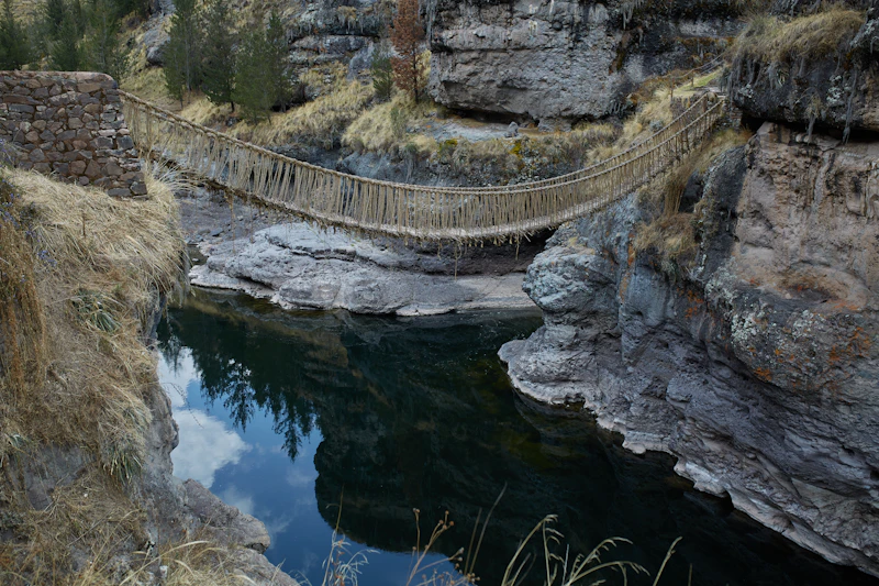 An Inca woven-grass rope bridge spanning a river canyon at Quehue, Peru