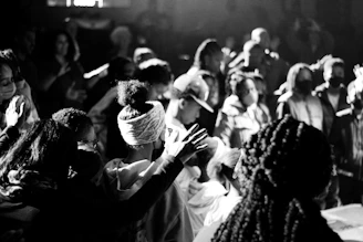A vibrant worship scene bathed in red and black lighting with the congregation united in praise.