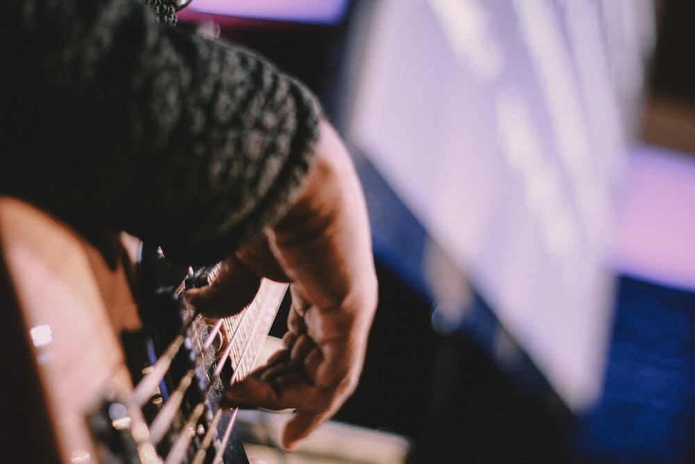 a person playing a guitar in front of a monitor