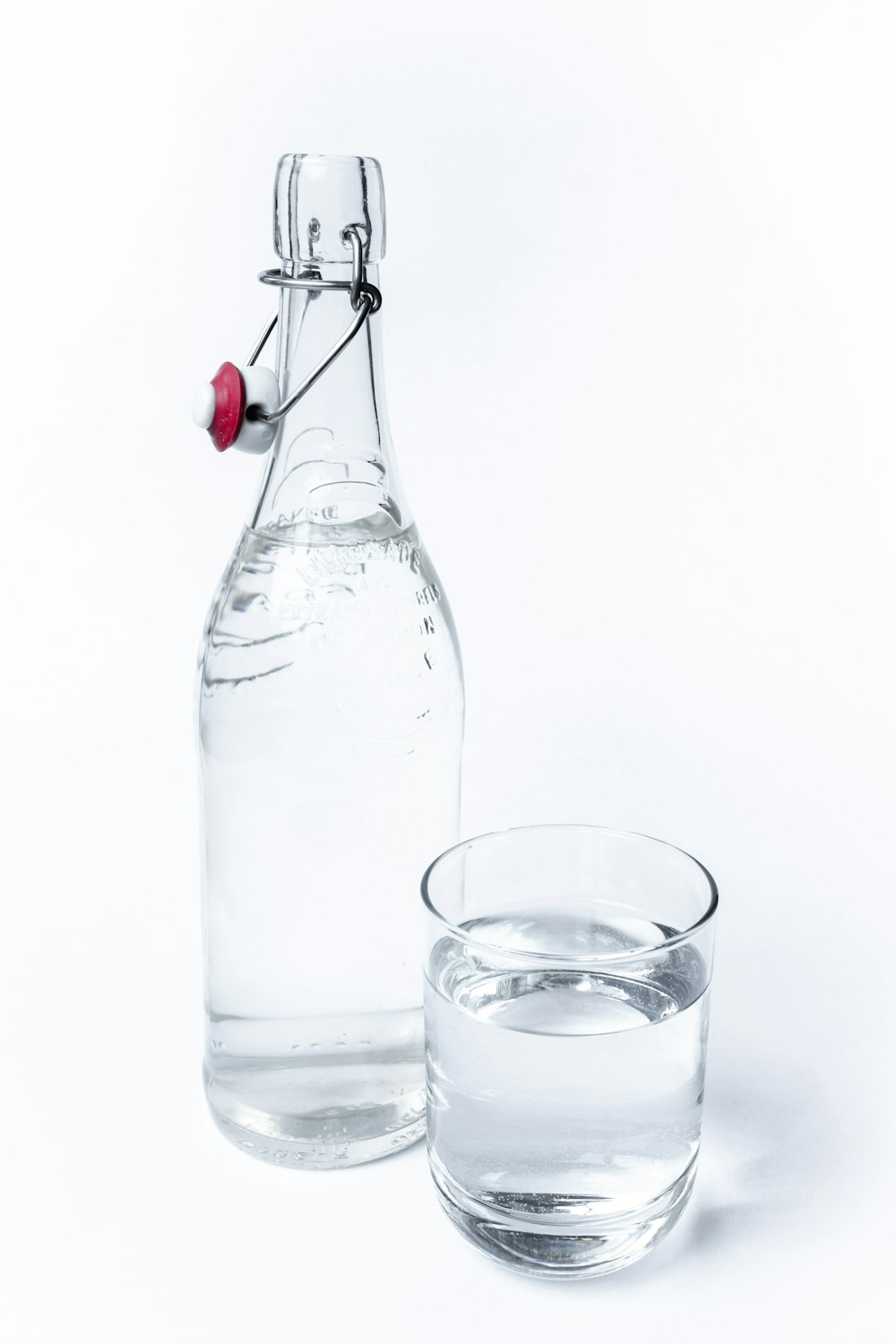 una bottiglia d'acqua accanto a un bicchiere d'acqua