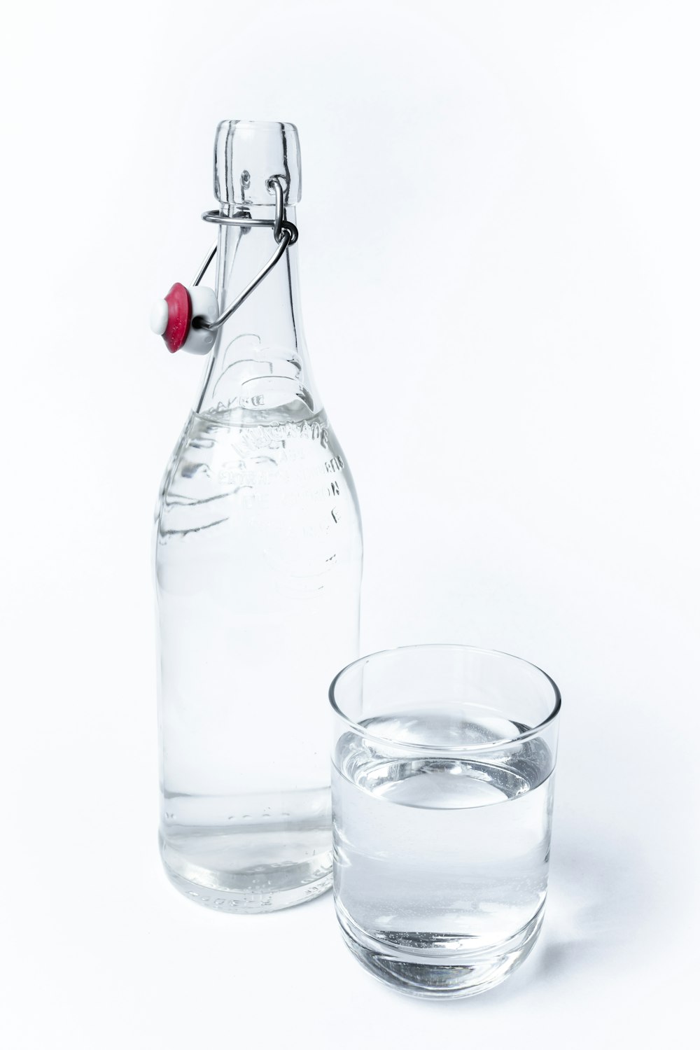 a bottle of water next to a glass of water