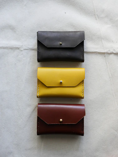 Elegant display of golden leather wallets arranged on a rich bordeaux velvet cloth.