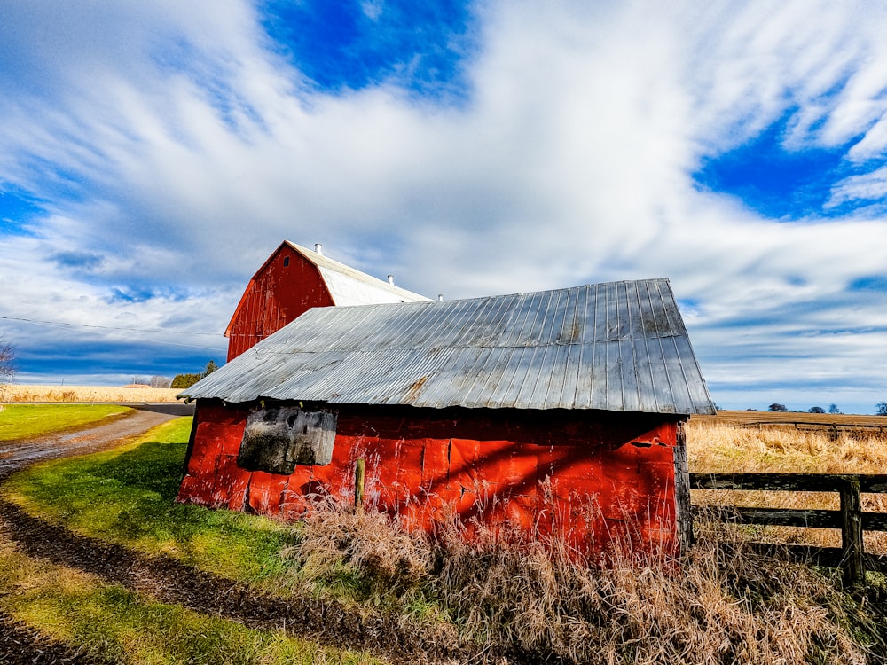 a red barn with a white roof in a field