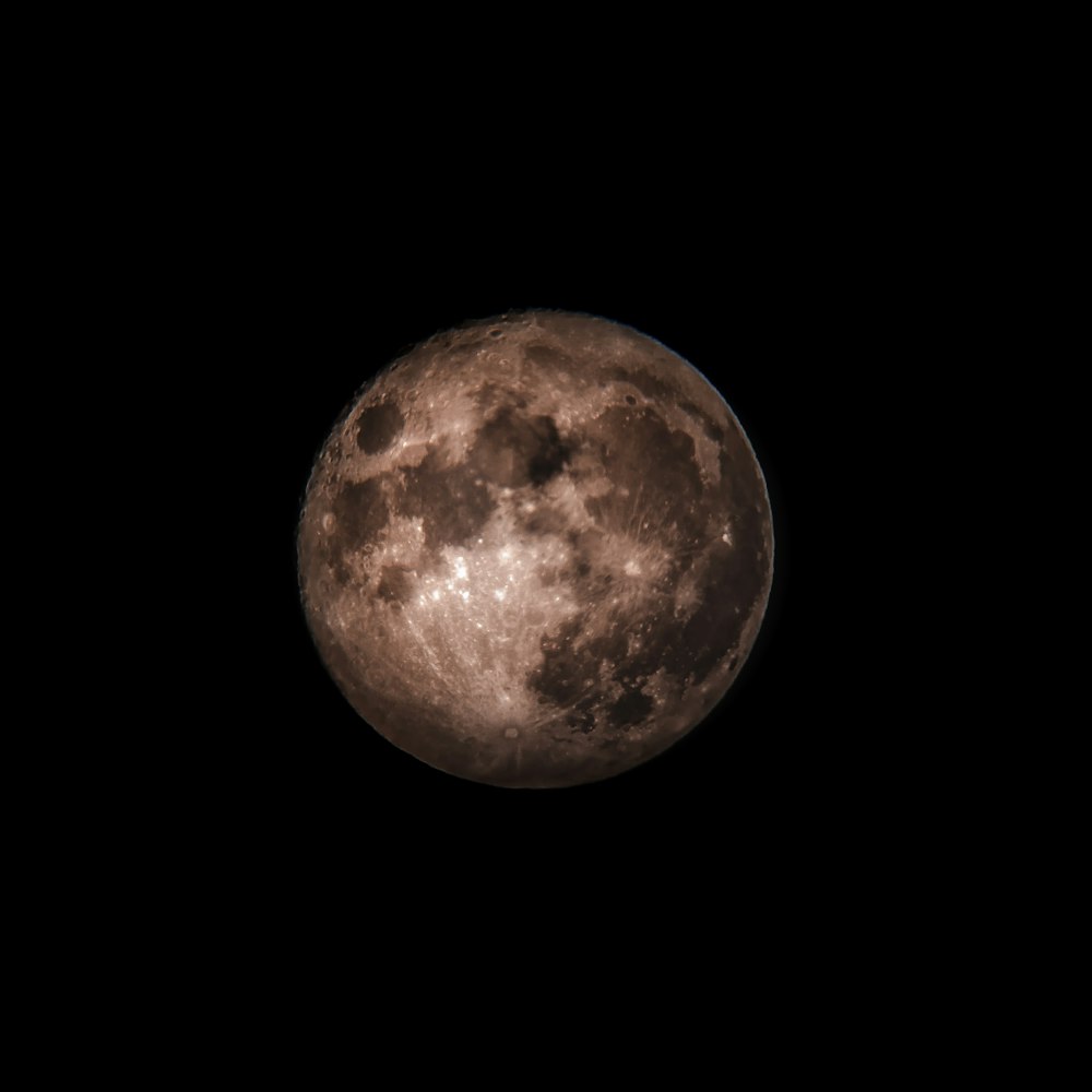 a full moon is seen in the dark sky