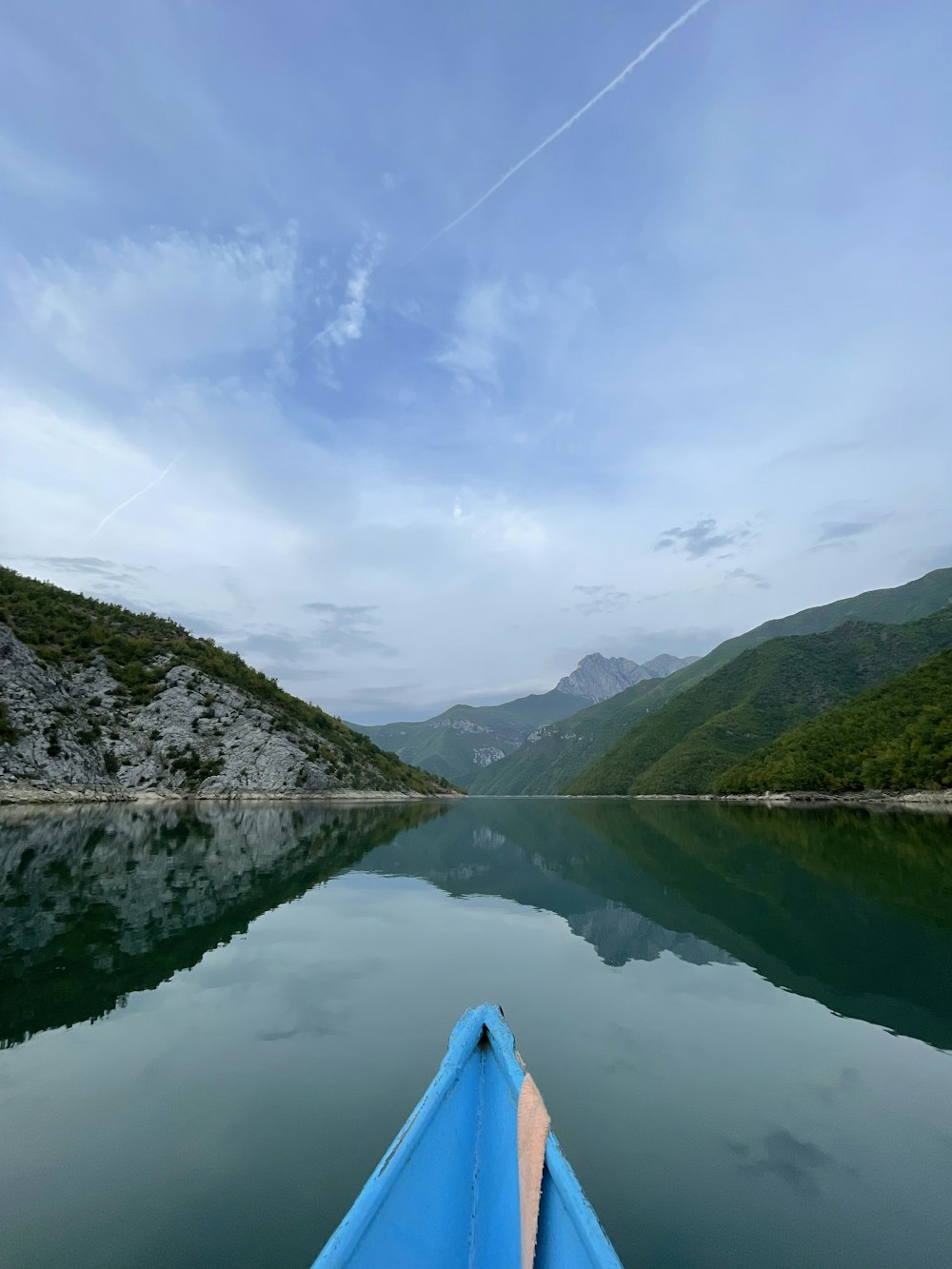 a blue boat floating on top of a lake