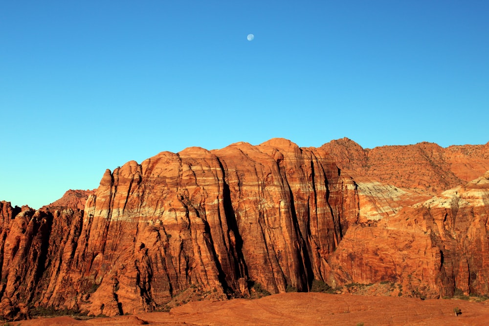 a view of a mountain with a moon in the sky