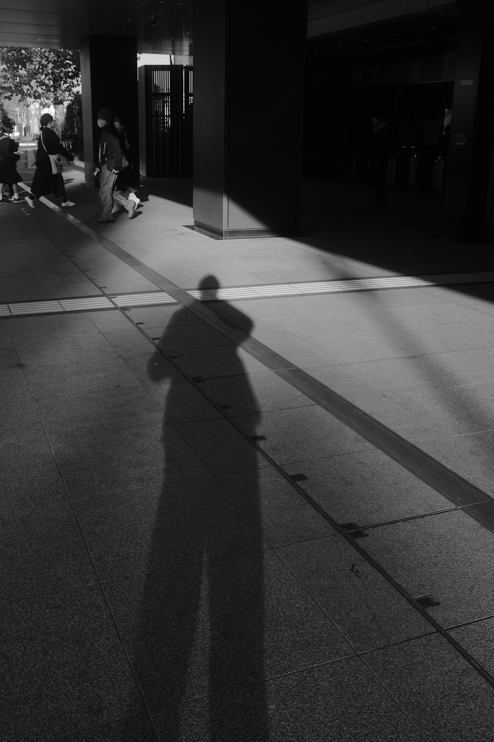 ein Schatten einer Person, die auf einem Bürgersteig steht