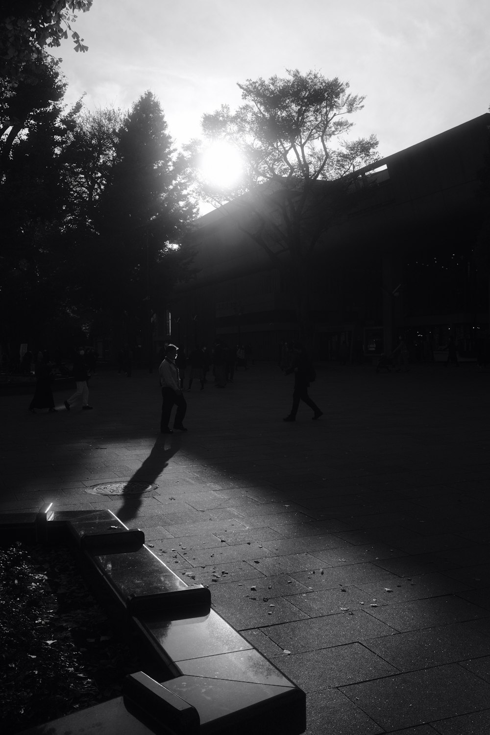 a black and white photo of a person standing on a bench