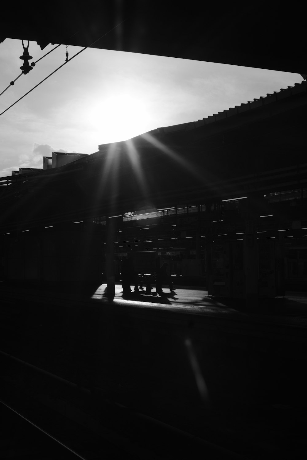 a train traveling past a train station under a cloudy sky