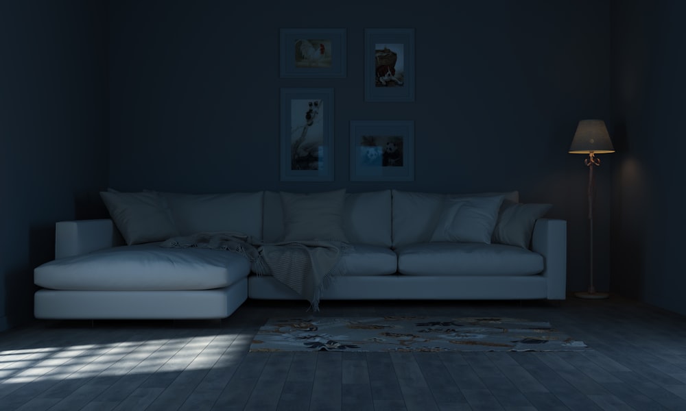 a living room with a white couch and a lamp