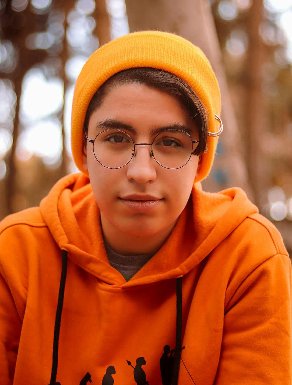 a young man wearing glasses and a yellow hat