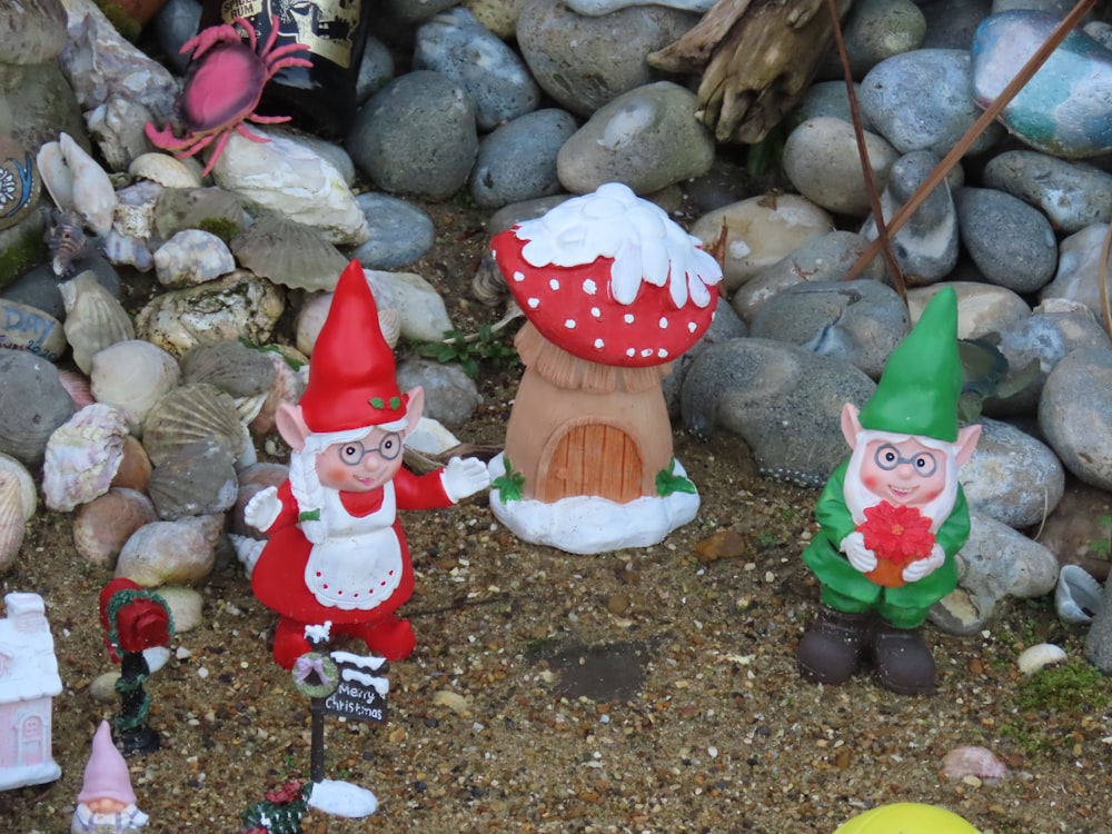 a group of garden gnomes sitting next to a pile of rocks