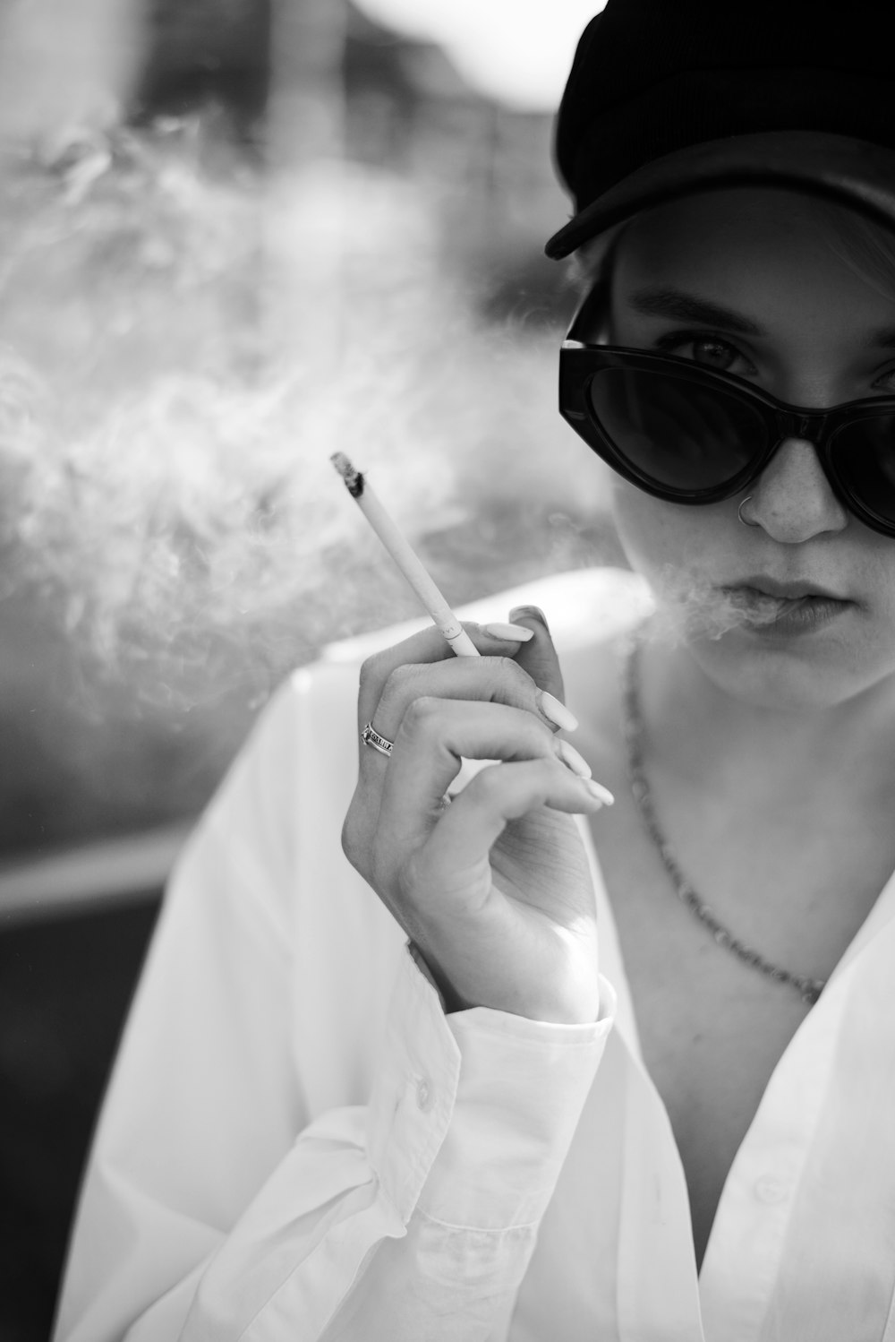 a woman smoking a cigarette in a black and white photo