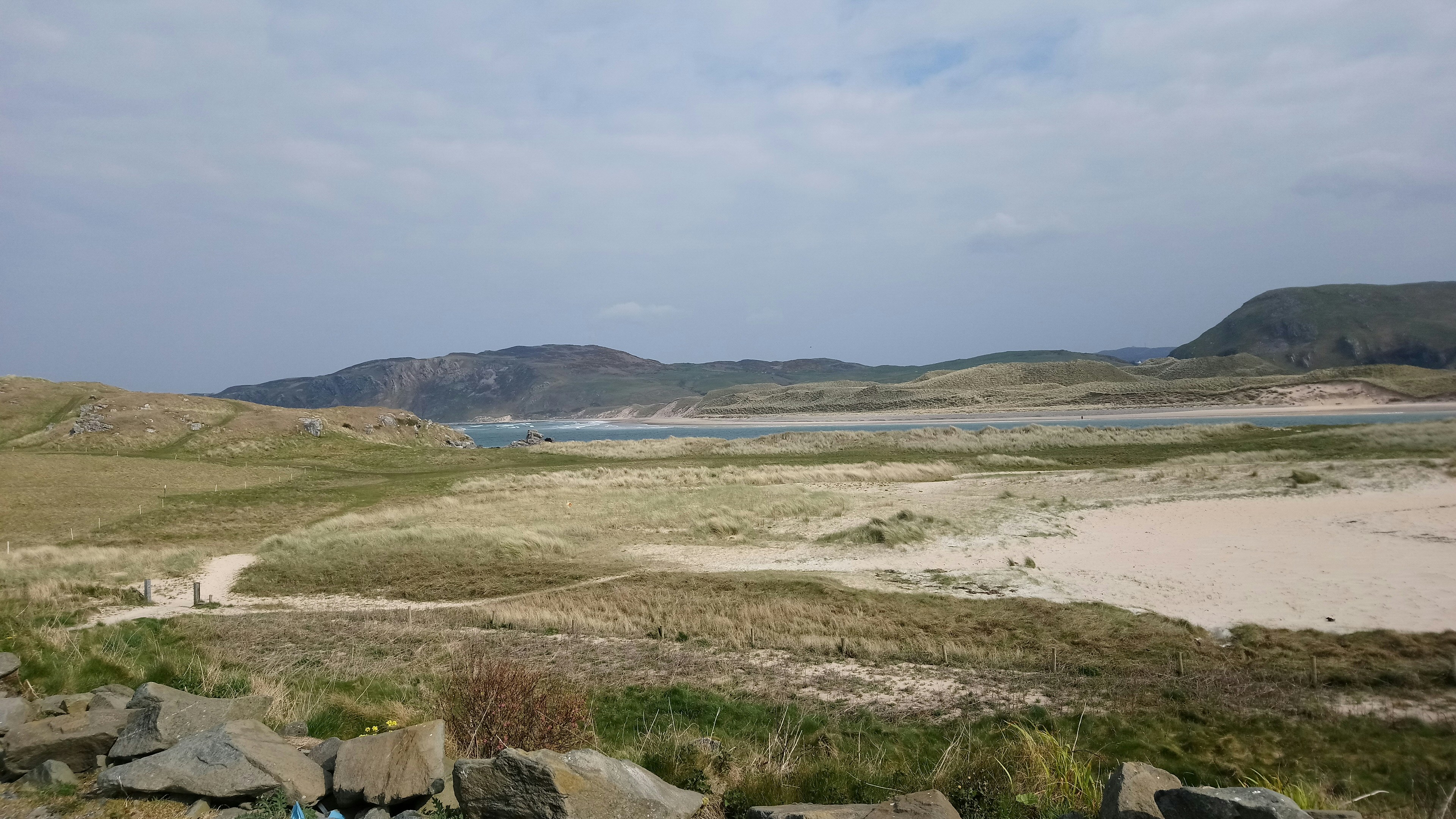 a view of a sandy beach with mountains in the background