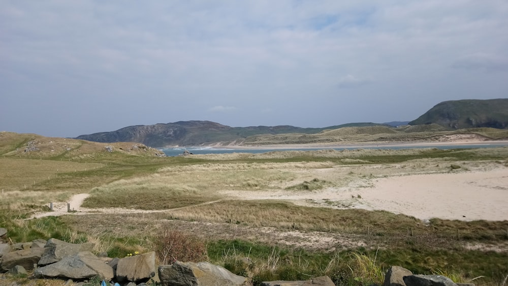 Una vista de una playa de arena con montañas al fondo