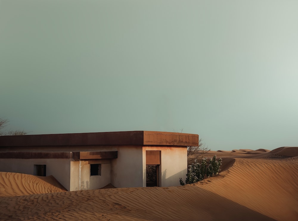 a small building sitting in the middle of a desert