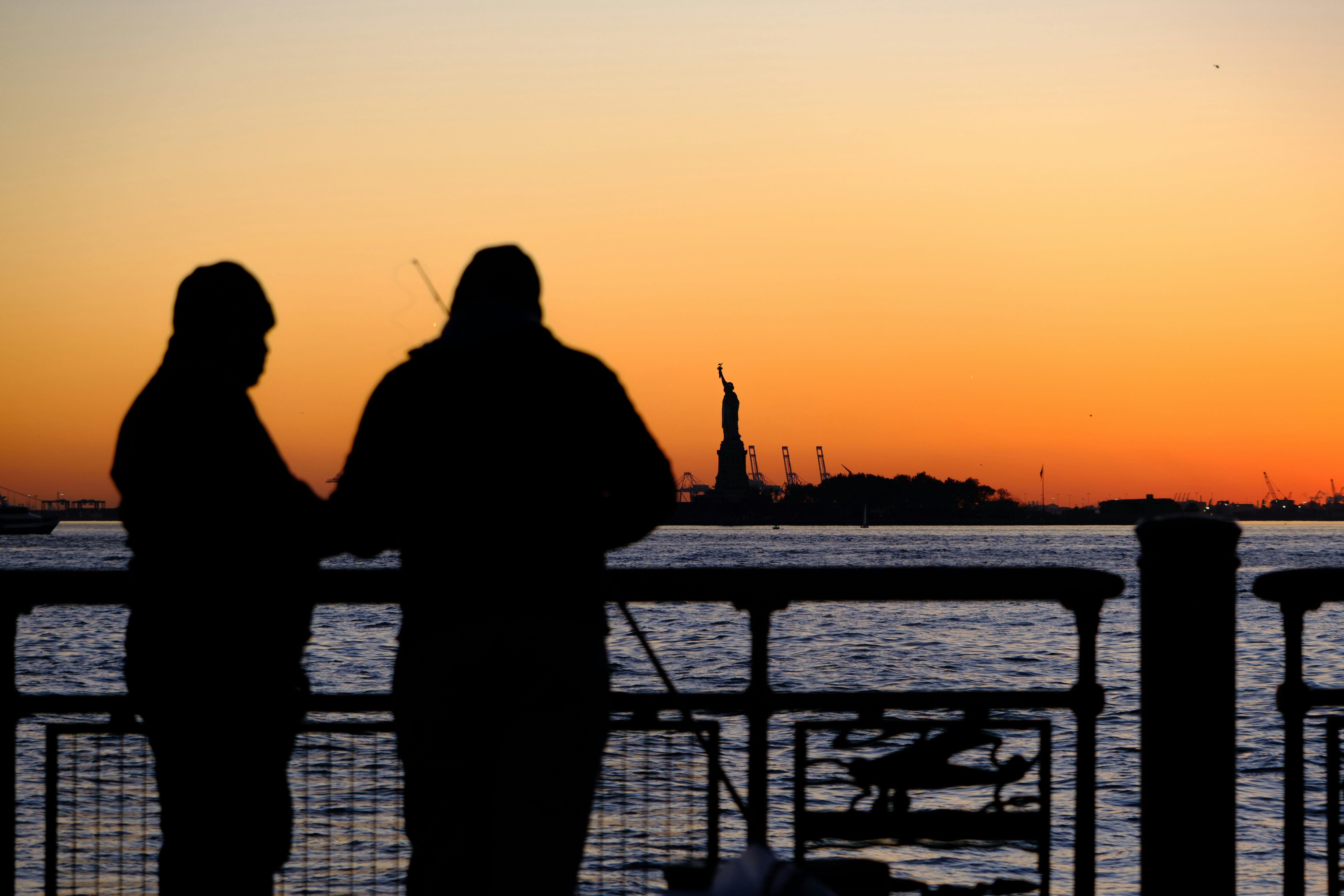 a couple of people standing next to a body of water