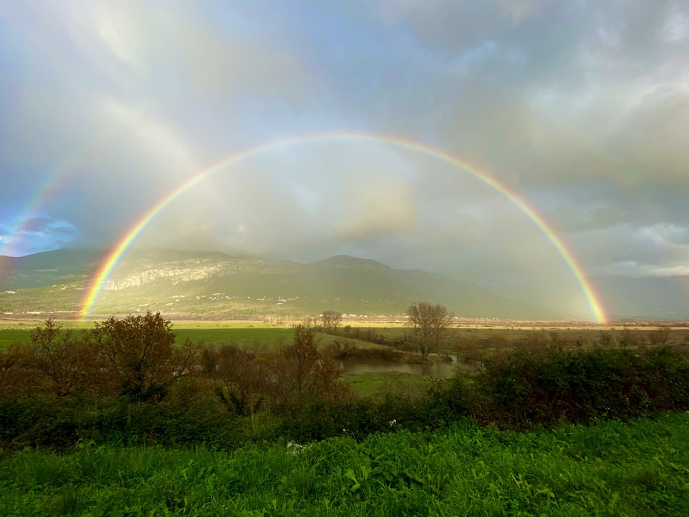 Deux arcs-en-ciel dans le ciel au-dessus d’un champ vert