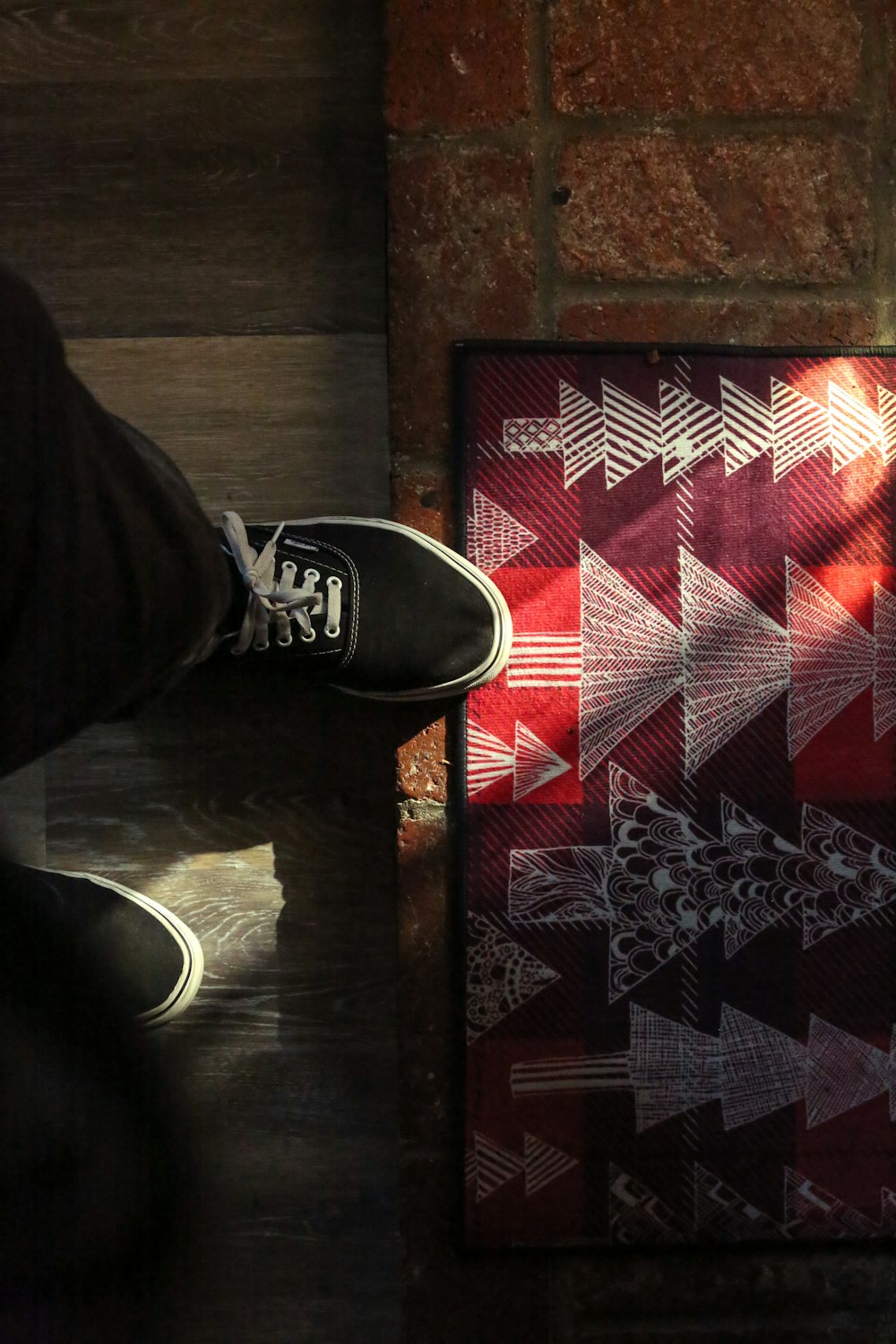 a person standing next to a red and white quilt