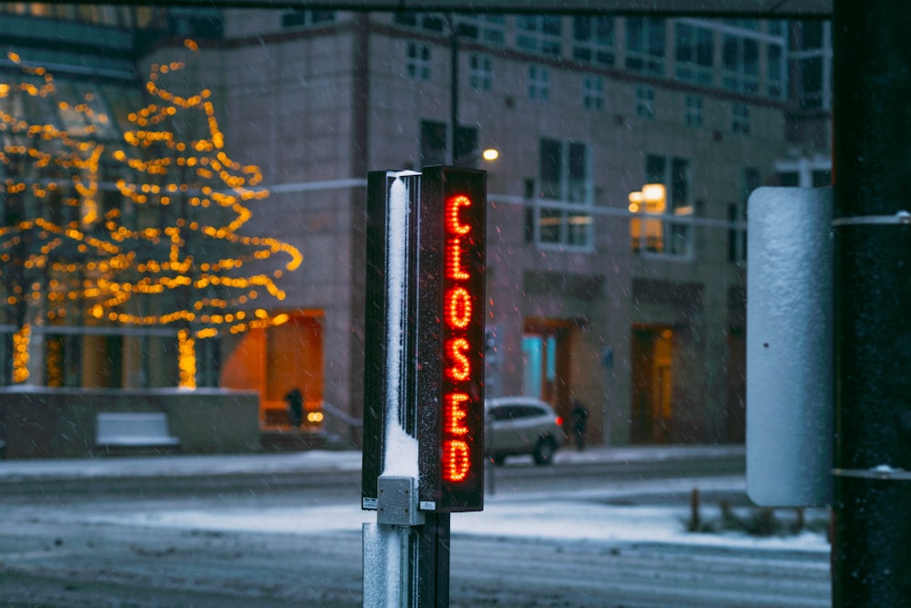 a street sign with a christmas tree in the background