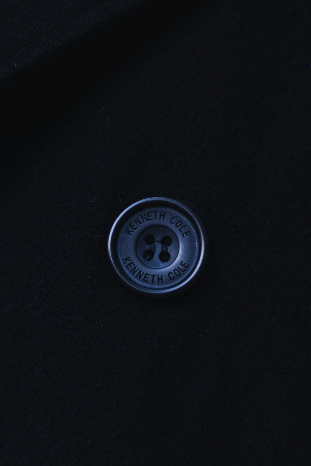 a close up of a button on a black coat