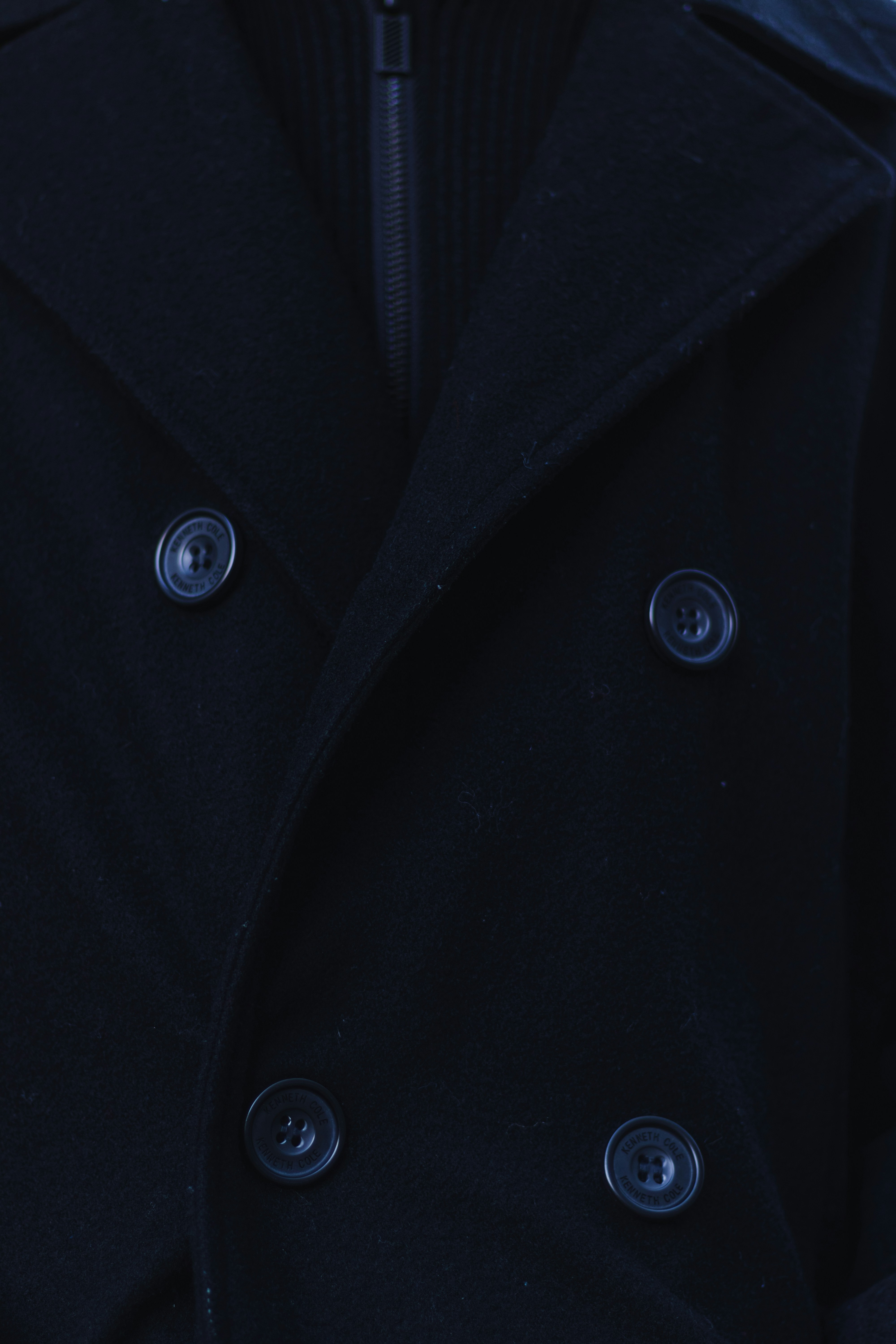 黒いピーコートと黒いシャツを着た男