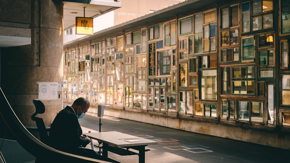 a man sitting on a bench in front of a building