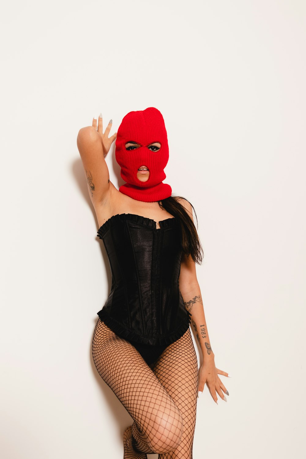 a woman in a black corset and a red mask