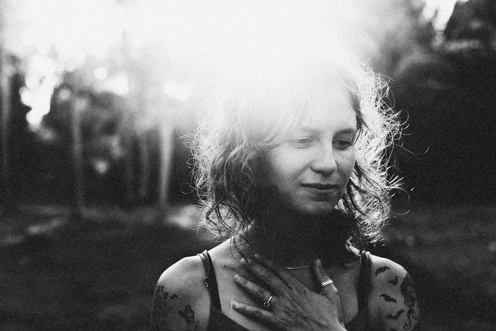 a black and white photo of a woman with tattoos