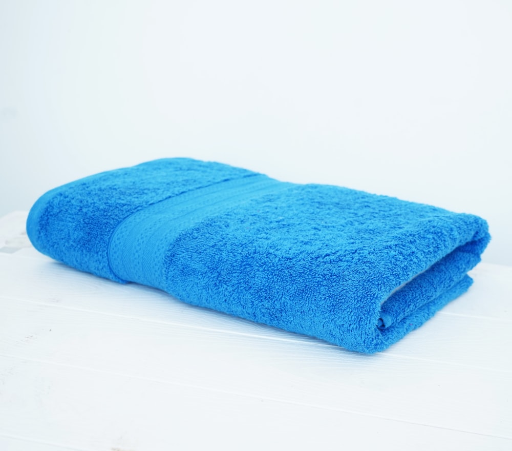 une serviette bleue posée sur une table blanche