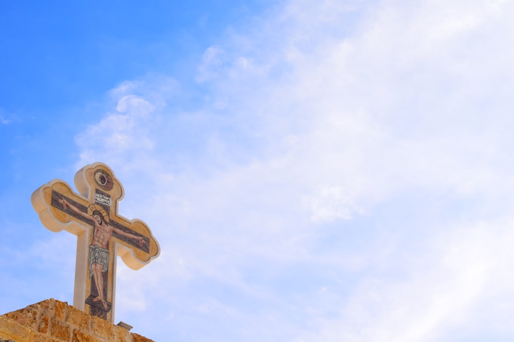 a cross on top of a building with a sky background