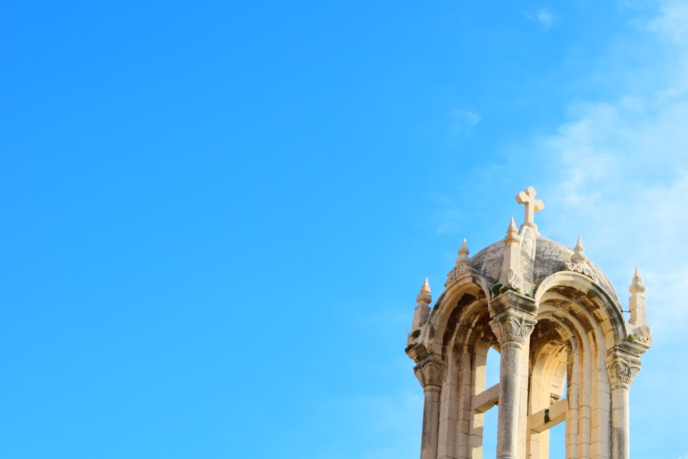 a tall tower with a cross on top of it