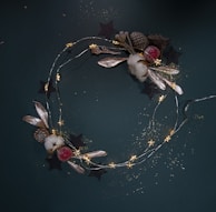 A festive holiday wreath with red berries, resin-coated holly leaves, and twinkling fairy lights woven throughout.