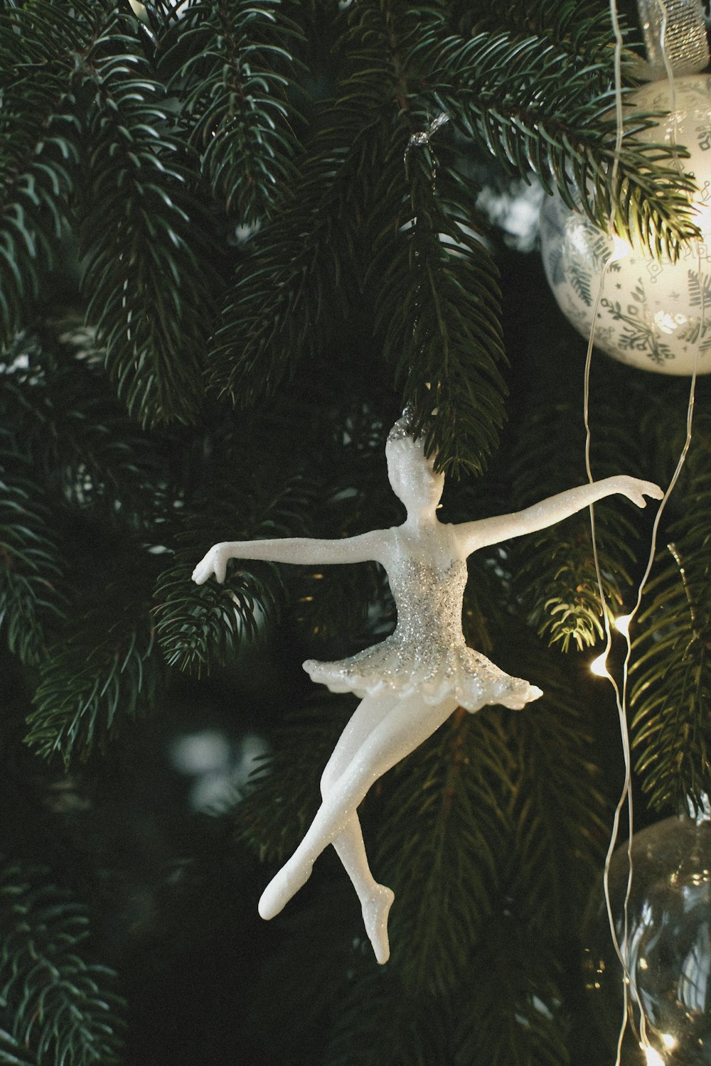 a white ornament hanging from a christmas tree