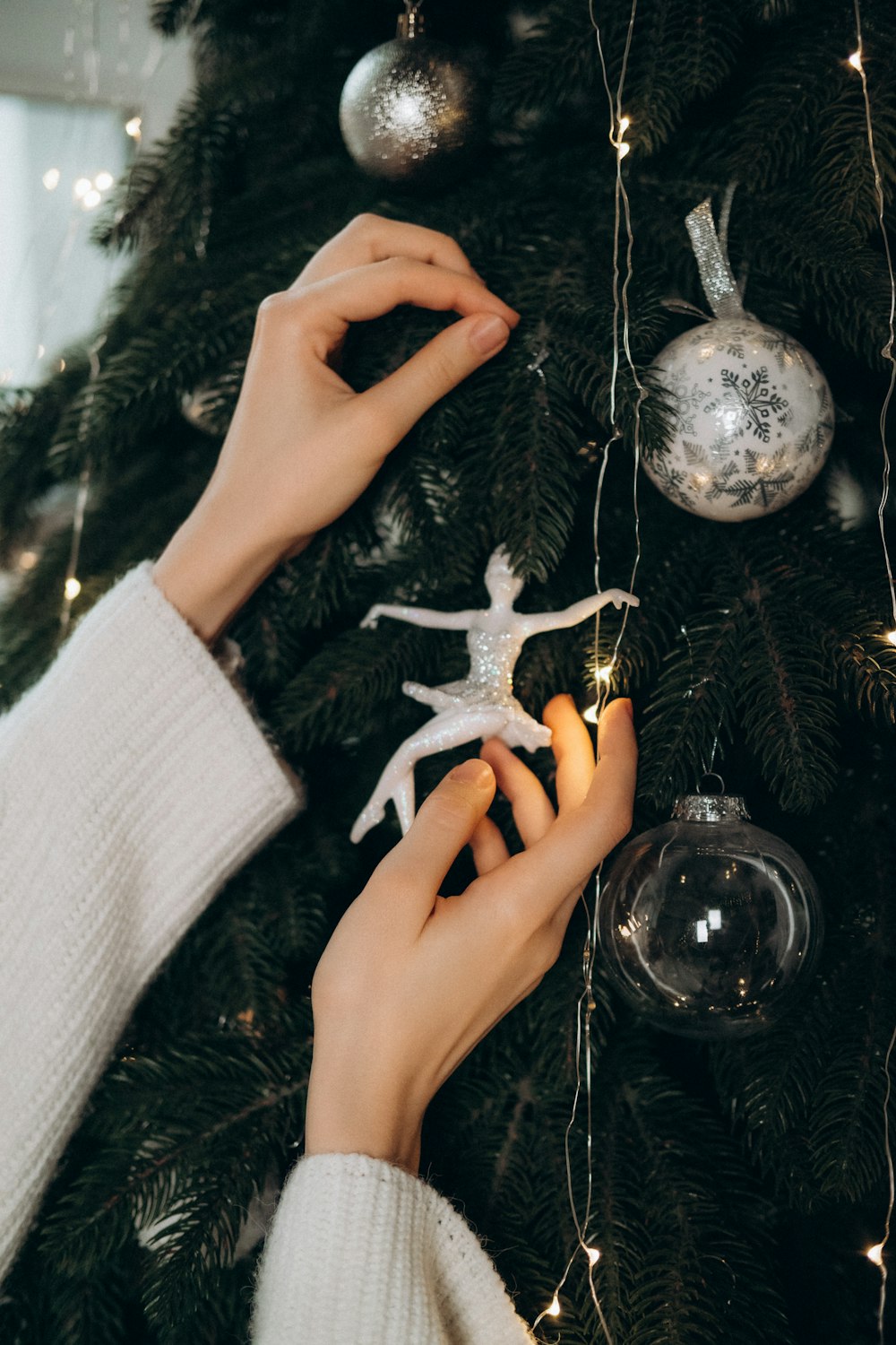 Una persona che decora un albero di Natale con ornamenti