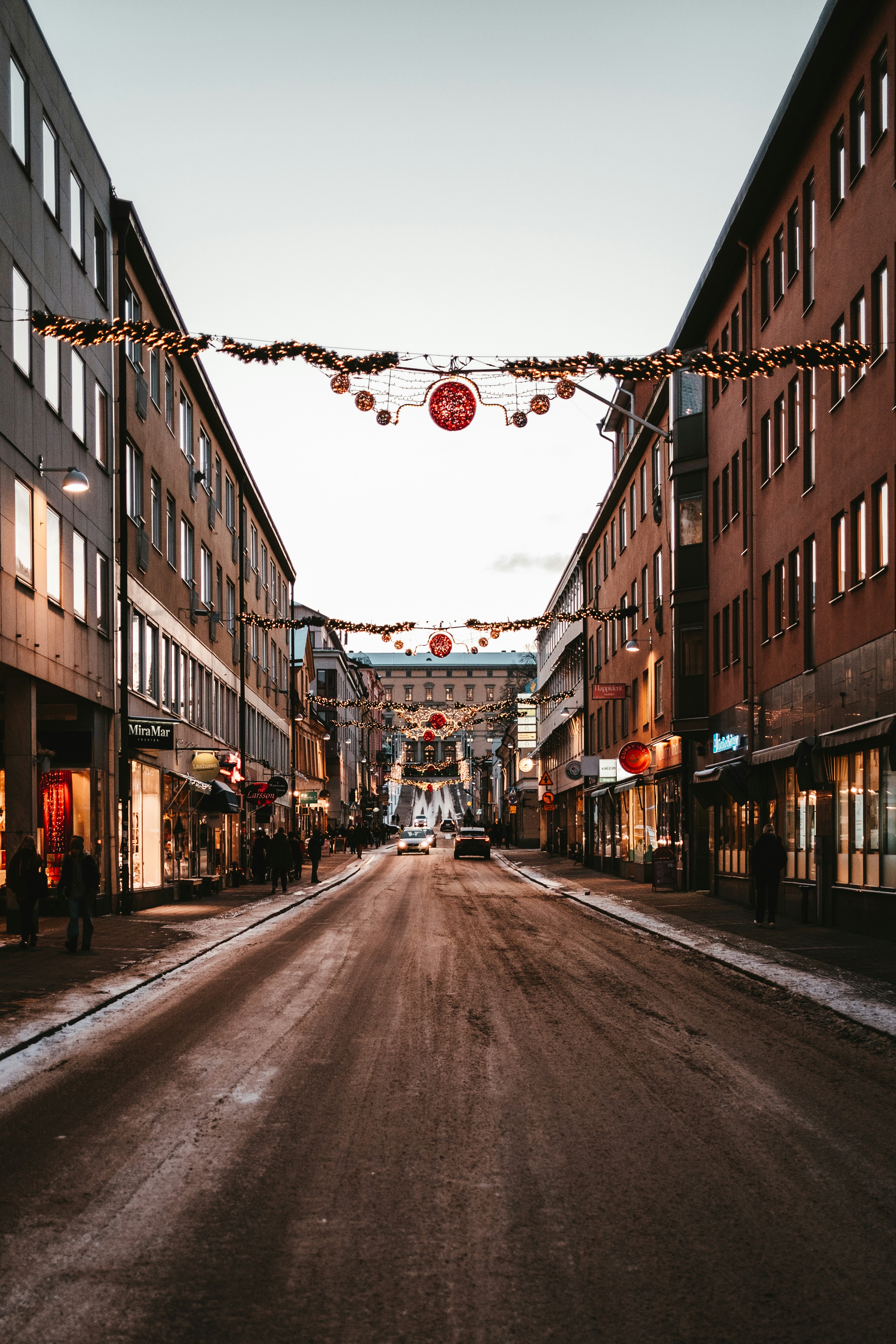an empty street with a string of lights hanging over it