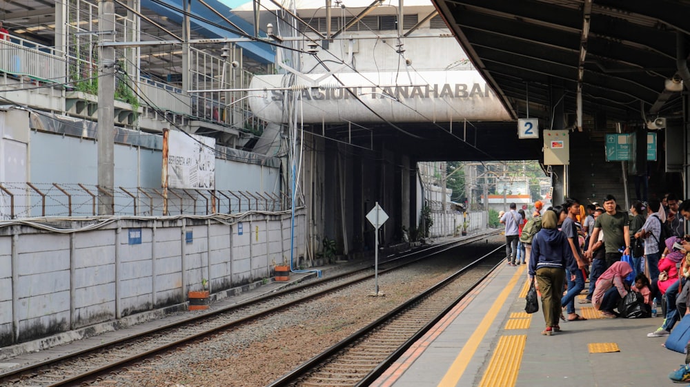 a group of people waiting for a train at a train station