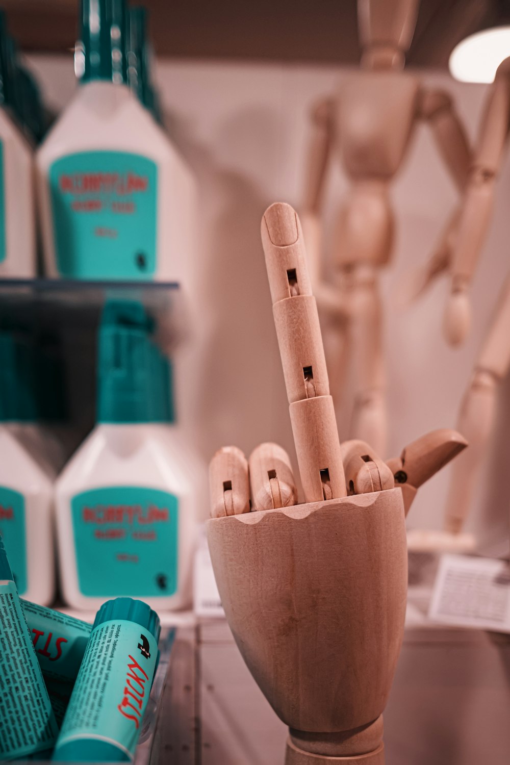 a wooden sculpture of a hand holding several bottles