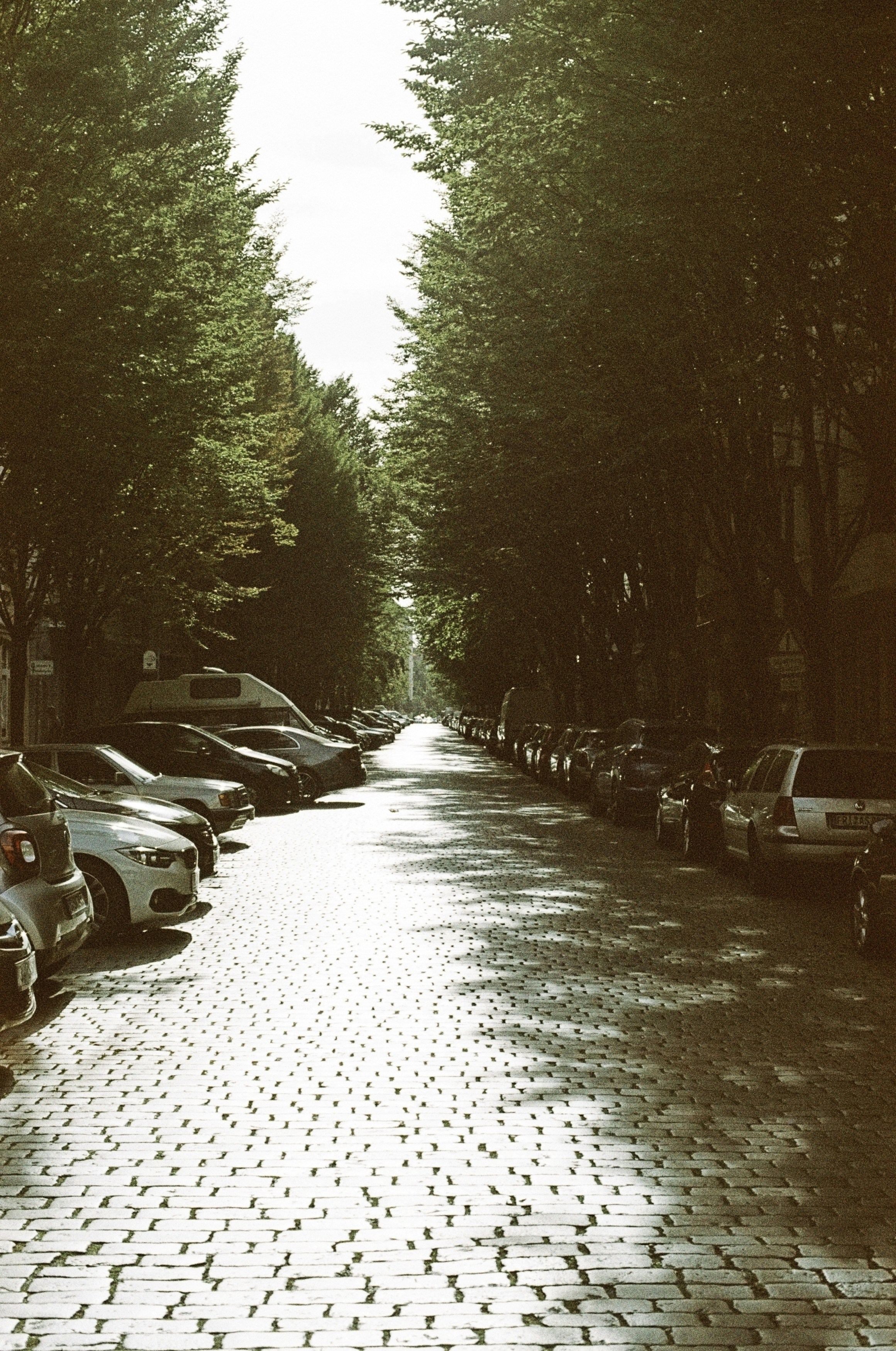 A row of parked cars sitting on the side of a road photo – Free Urban ...