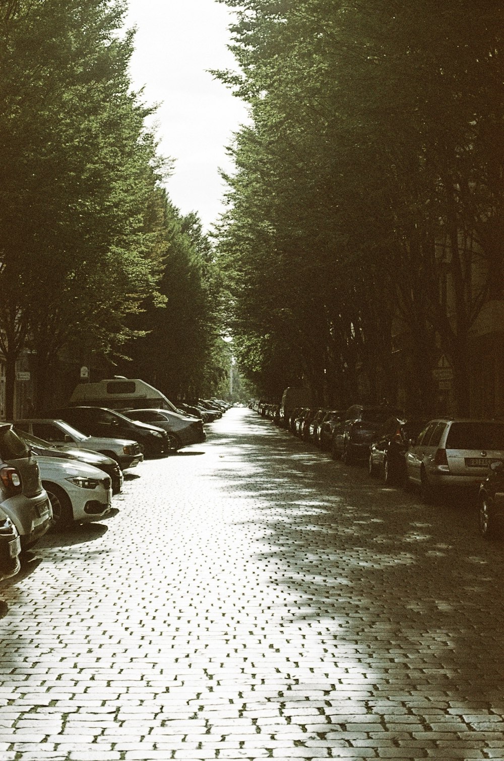 a row of parked cars sitting on the side of a road