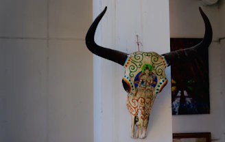 Close-up of a beautifully restored cattle skull with intricate hand-painted desert motifs.