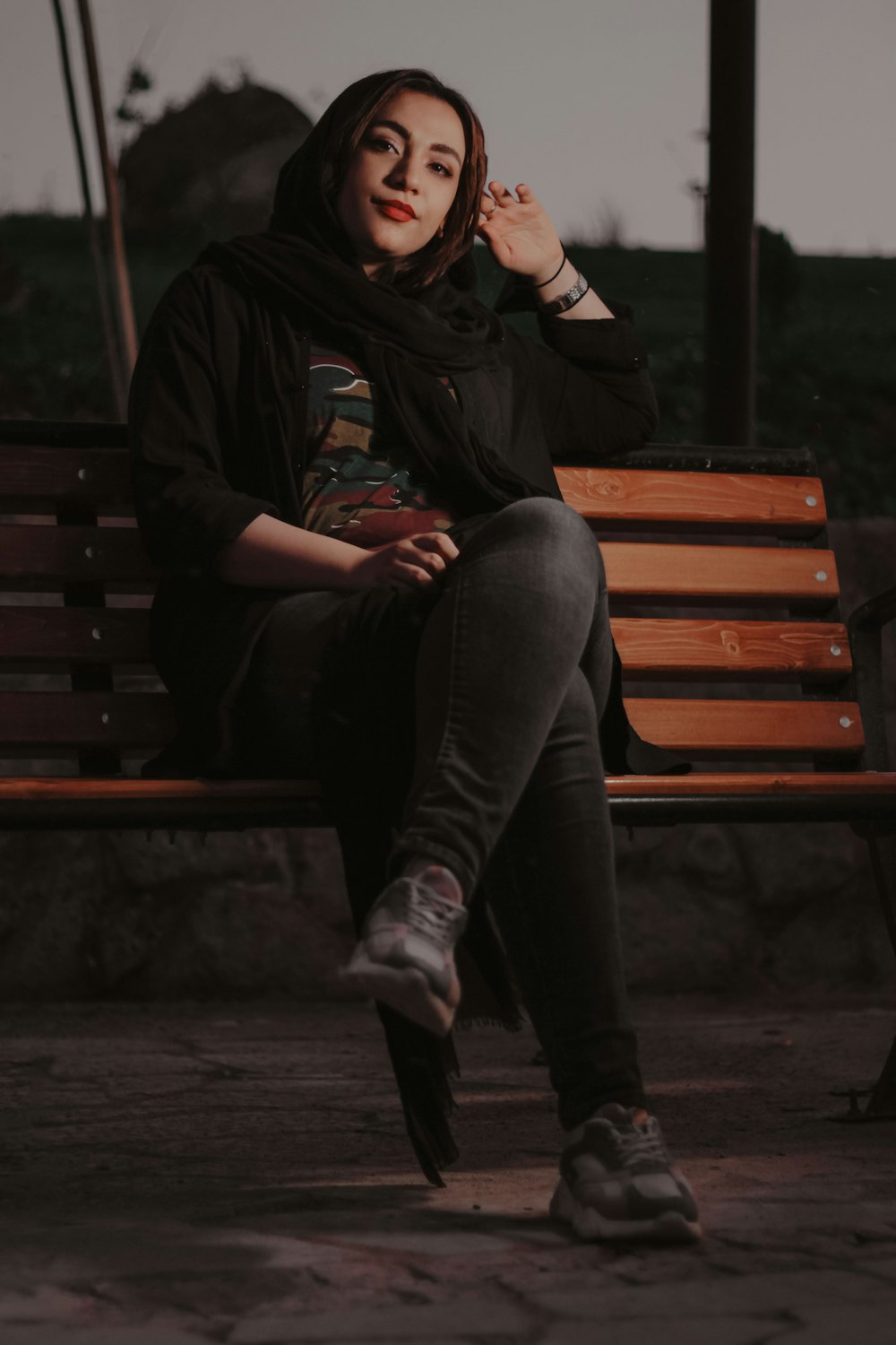 a woman sitting on a bench smoking a cigarette